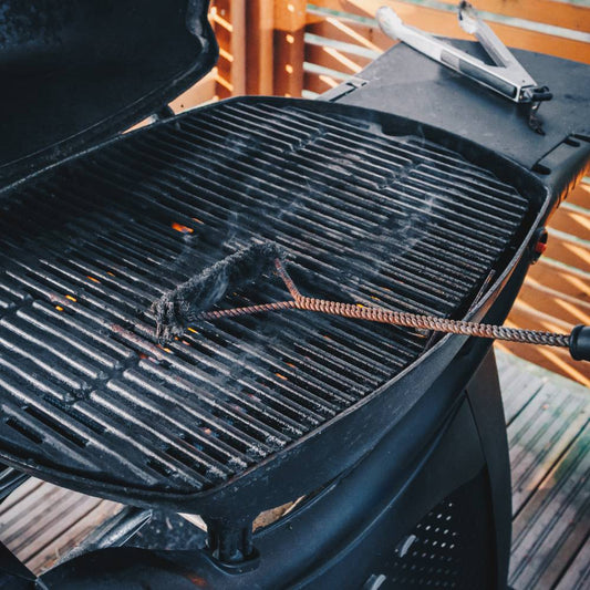 Cleaning outdoor barbecue grill with a wire brush