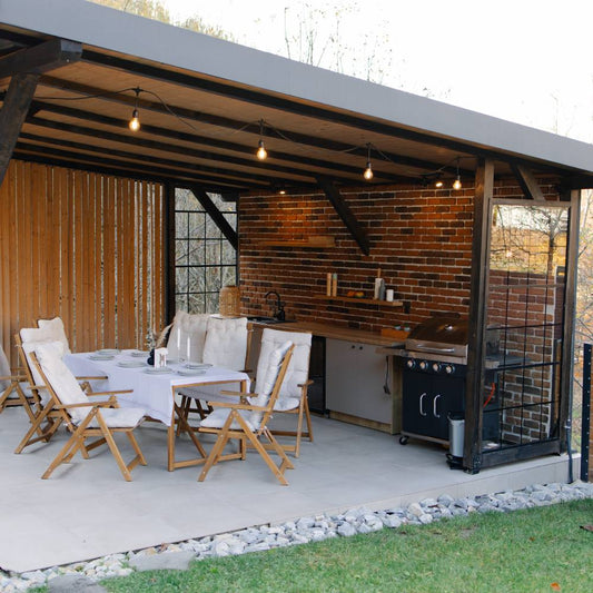 Outdoor kitchen and dining area under modern gazebo structure